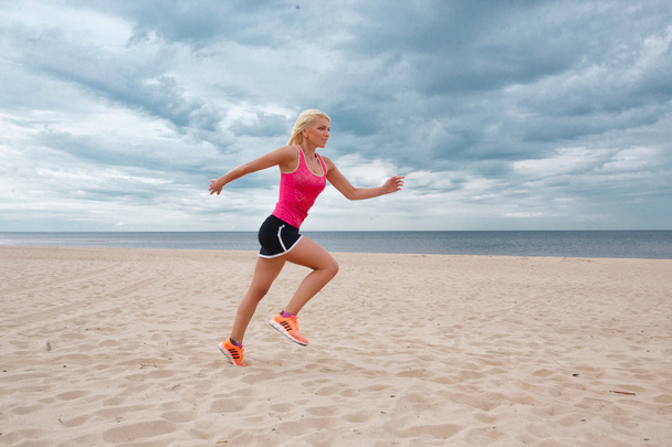 Σπορ ξανθιά γυναίκα που τρέχει στην παραλία - Φωτογραφία, εικόνα