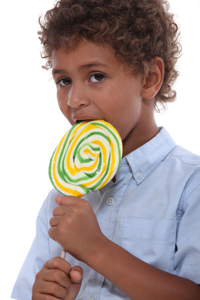 Young boy licking a lollipop - Фото, зображення