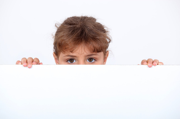 Girl peeking above a board - Photo, image