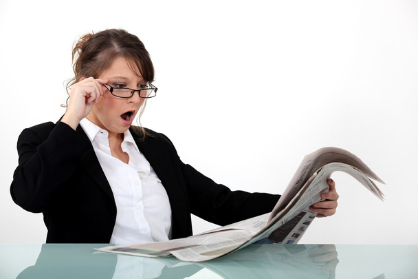 Businesswoman shocked at her newspaper - Photo, Image