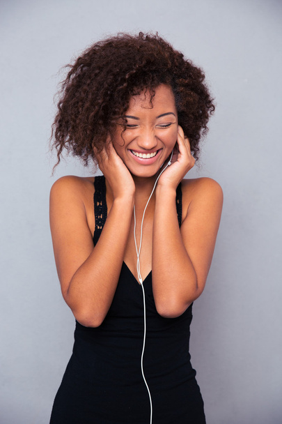 Afro american woman listening music in headphones - Фото, изображение