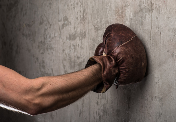Tough caucasian male's hand in old vintage boxing gloves, ready to fight - 写真・画像