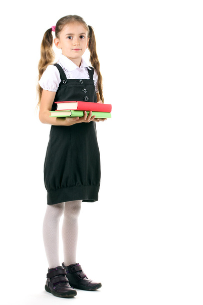 όμορφο κοριτσάκι στη σχολική στολή και τα βιβλία που απομονώνονται σε λευκό - Φωτογραφία, εικόνα