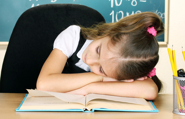 Little schoolgirl sleep in classroom near blackboard - Photo, Image