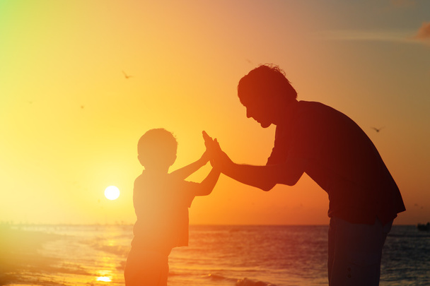 Ojciec i syn zabawy na zachodzie słońca - Zdjęcie, obraz