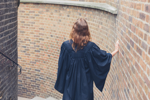 Woman in graduation gown on stairs - Фото, зображення