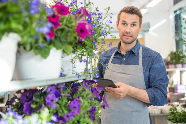 Confident Worker Using Digital Tablet In Flower Shop - Fotó, kép