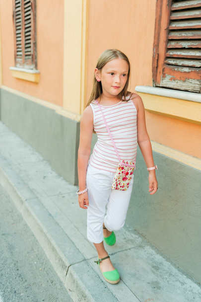 Retrato al aire libre de una linda niña de moda con pantalones blancos y zapatos verdes
 - Foto, Imagen