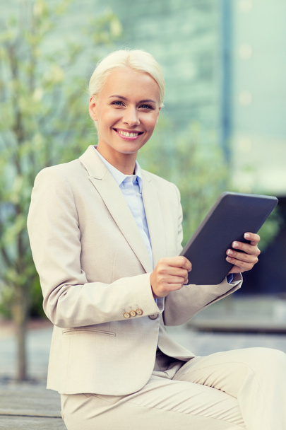 smiling businesswoman with tablet pc outdoors - Valokuva, kuva