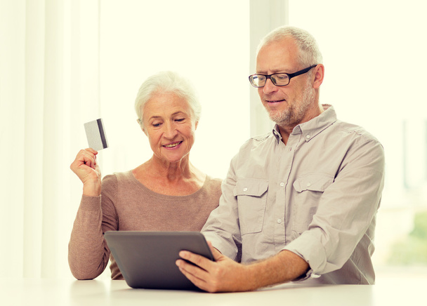 heureux couple aîné avec tablette PC et carte de crédit
 - Photo, image