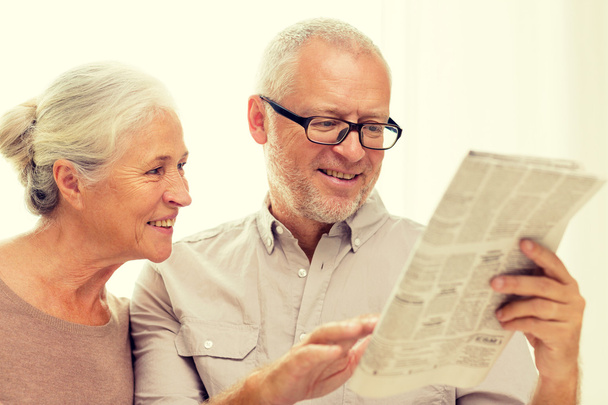 happy senior couple reading newspaper at home - Fotó, kép