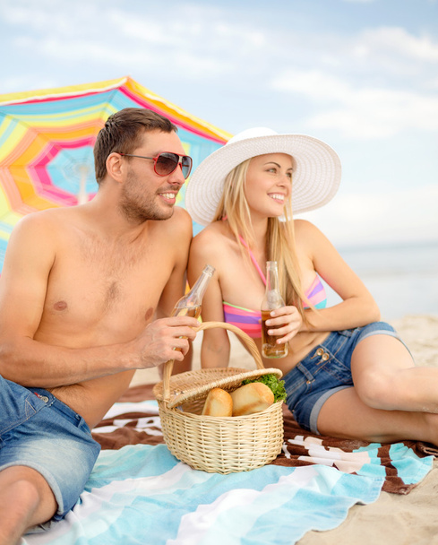 happy couple having picnic and sunbathing on beach - Valokuva, kuva