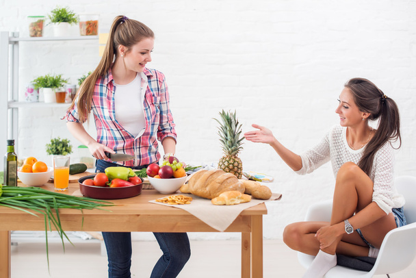 Mujer cocinando en una cocina y hablando con su amigo concepto de preparación de la amistad culinaria
. - Foto, Imagen