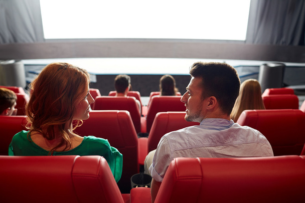 happy couple watching movie in theater or cinema - 写真・画像