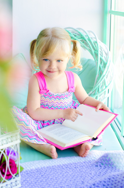 pouco engraçado menina leitura livro perto da janela
 - Foto, Imagem