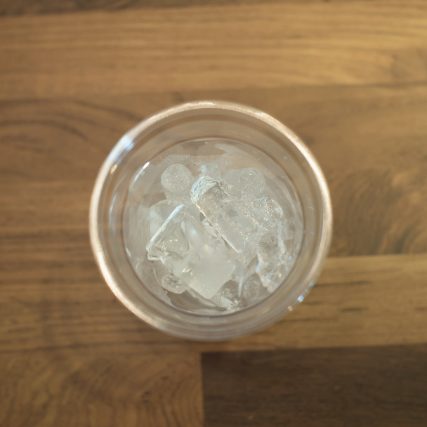 gelo em vidro plástico na mesa de madeira
 - Foto, Imagem