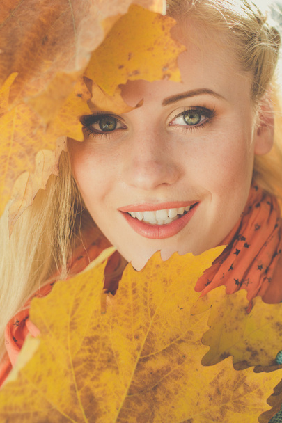 Gesicht eines Mädchens mit gelben Ahornblättern - Foto, Bild
