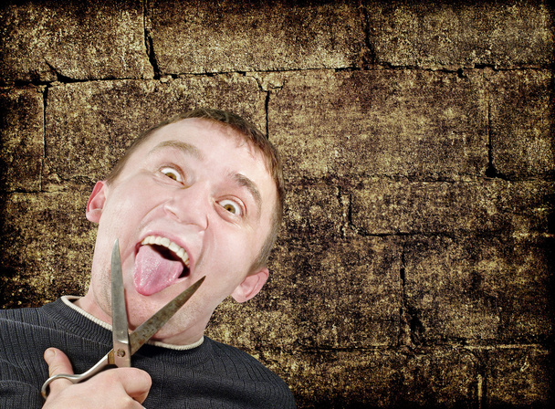 Mad man with scissors cuts off itself tongue on grunge backgroun - Photo, Image