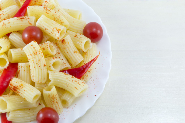 Pasta con pomodorini e peperoncino servita in un piatto bianco
 - Foto, immagini