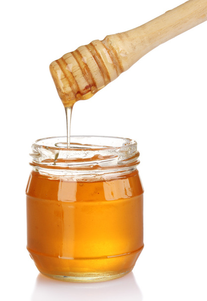 Jar of honey and wooden drizzler isolated on white - Φωτογραφία, εικόνα