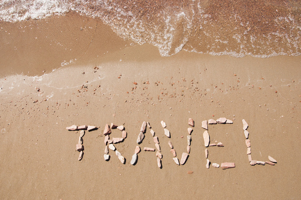 matkustaa kirjoitettu hiekkarannalla lähellä merta
 - Valokuva, kuva