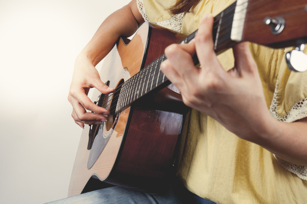 kobieta z rąk gra na gitarze, z bliska. Vintage ton - Zdjęcie, obraz