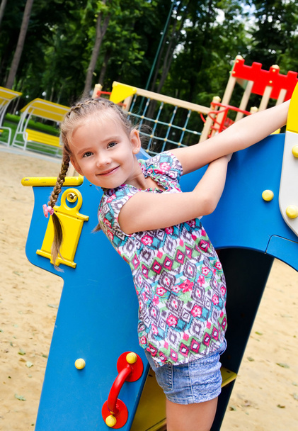 Sorrindo menina brincando em equipamentos de playground
  - Foto, Imagem