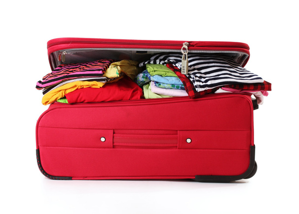 Сlosed red suitcase with clothing isolated on a white - Photo, image