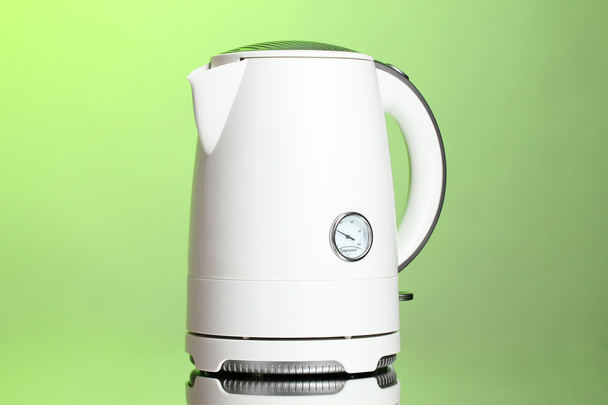 White electric kettle on green - Fotoğraf, Görsel