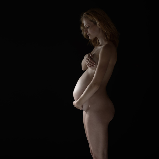 pregnant woman embracing her belly - Фото, изображение
