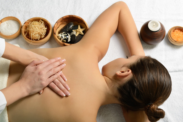 vrouw in spa omgeving krijgt massage - Foto, afbeelding