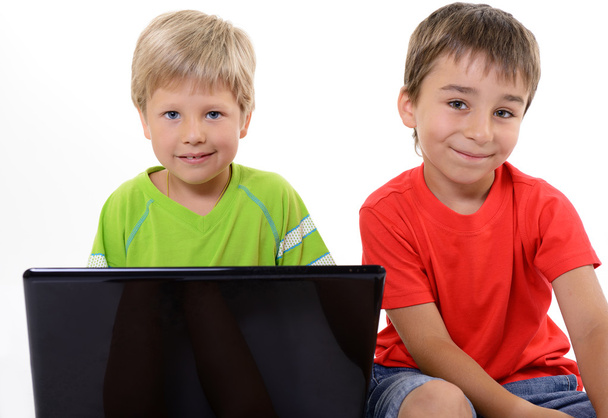 Portrait of smart schoolboys looking at the laptop, over white - Fotoğraf, Görsel