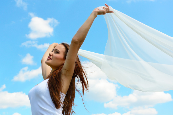 žena držící bílou šálu proti obloze - Fotografie, Obrázek