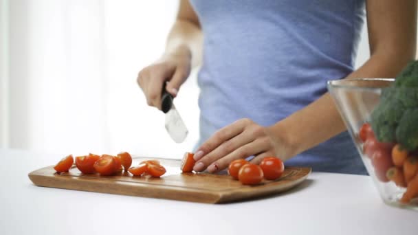 close up of young woman chopping tomatoes at home - Video, Çekim