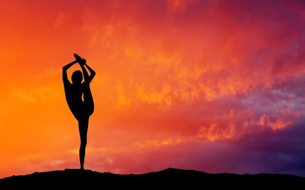 Sylwetka kobiety jogi w godzinach wieczornych. Kobieta robi joga w s - Zdjęcie, obraz