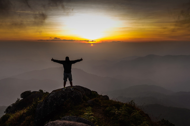 Escursionista a braccia aperte sulla cima della montagna al tramonto
. - Foto, immagini