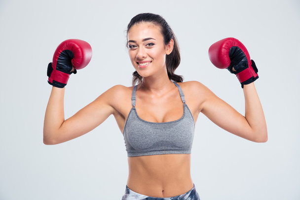 Fitness woman standing with boxing gloves in victory pose - Фото, изображение