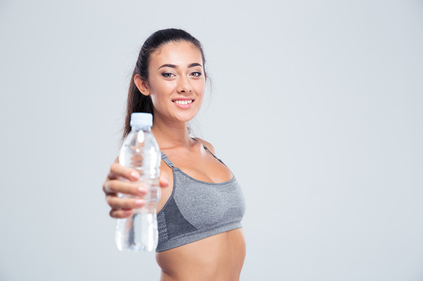 Smiling fitness woman holding bottle with water  - Foto, imagen
