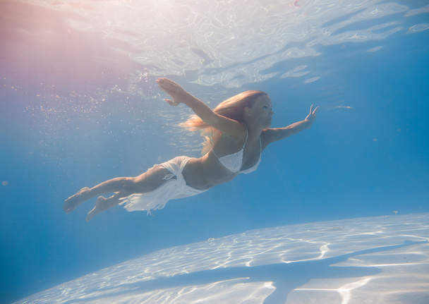 Young woman swimming underwater - Foto, Bild
