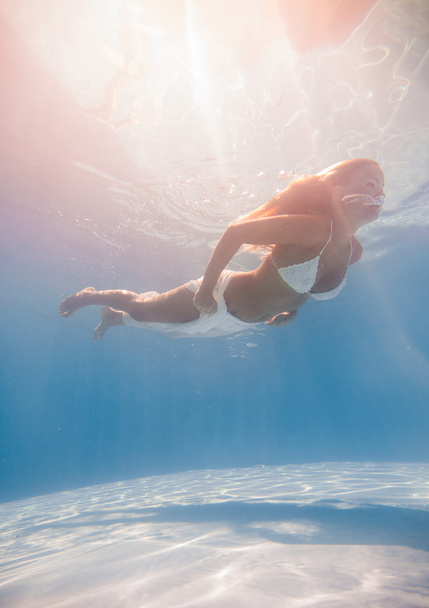 Young woman swimming underwater - Foto, Bild