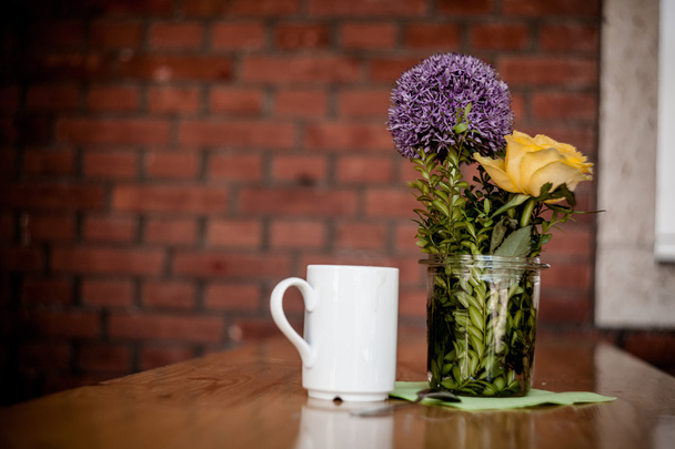 Cup of coffee and beautiful flowers on wooden background - Foto, imagen