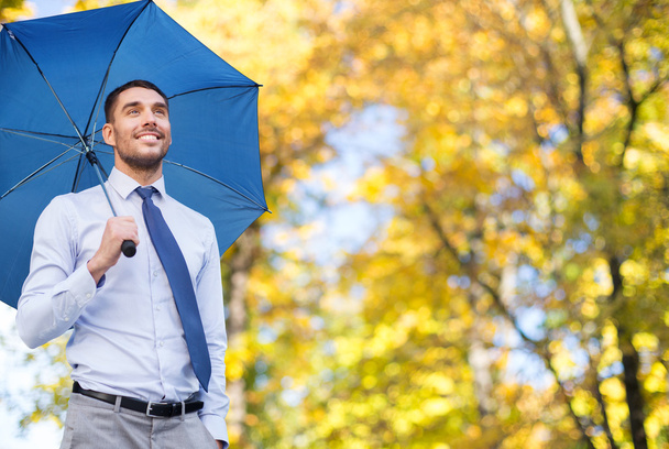 businessman with umbrella over autumn background - Zdjęcie, obraz