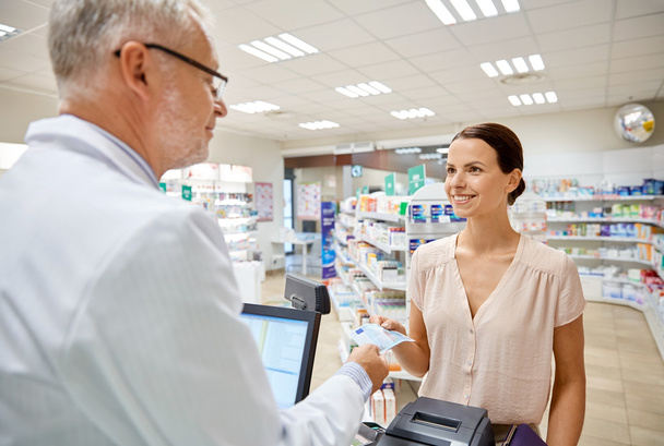 woman giving money to pharmacist at drugstore - Фото, зображення