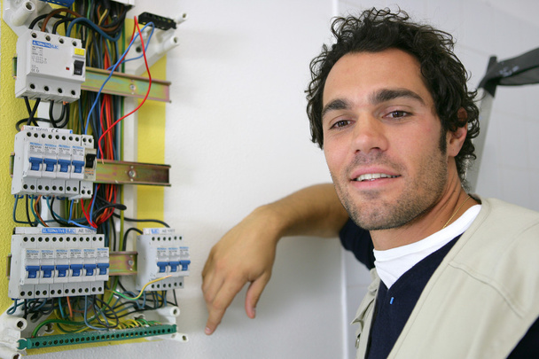 Joven electricista posando cerca de medidor eléctrico
 - Foto, imagen