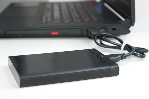  внешний жесткий диск подключение к ноутбуку компьютера на белом
. - Фото, изображение