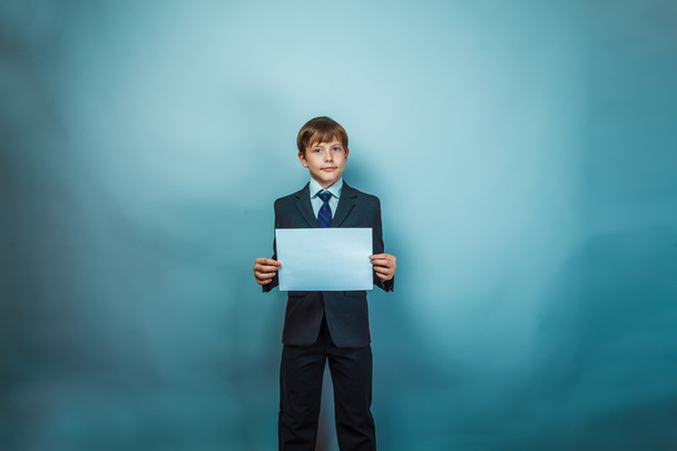 Teen boy businessman holding a white paper sign studio photo - Photo, Image