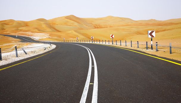 kurvenreiche schwarze Asphaltstraße durch die Sanddünen der liwa oase, vereinigte arabische Emirate - Foto, Bild