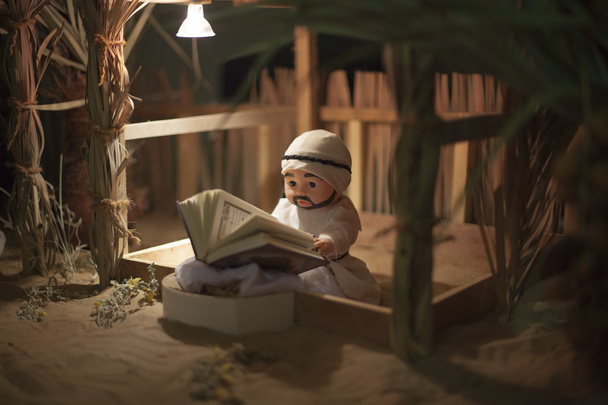 Hombre árabe tradicional leyendo juguete en miniatura del Corán, Emiratos Árabes Unidos
 - Foto, imagen