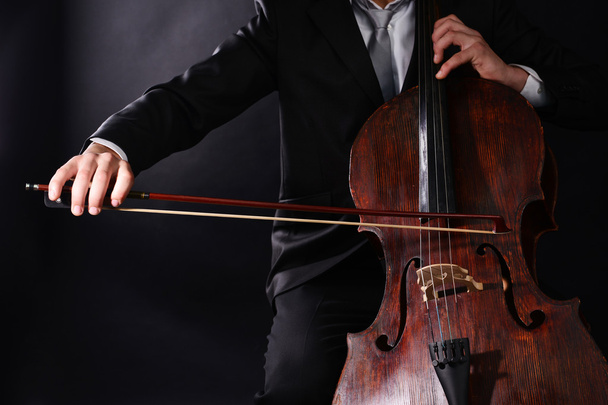 Man playing on cello on dark background - Zdjęcie, obraz