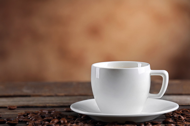 Cup of coffee and beans on blurred background - Foto, Bild